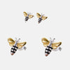 Boucles d'oreilles corp de l'abeille en argent les ailes sont plaquées et or thème abeille sur un fond gris clair.