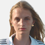 Boucles d'oreilles corp de l'abeille en argent les ailes sont plaquées et or thème abeille sur un visage de femme aux  cheveux long blonds 